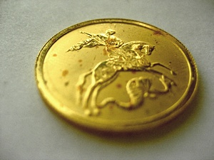 Золотая монета с пятнами ржавчины